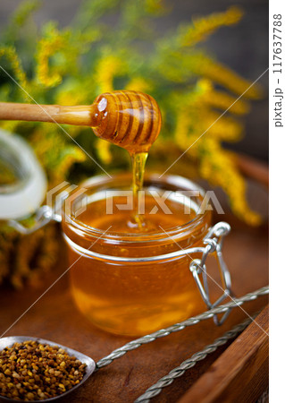 Bee honey and a wooden spoon. Sweet food. 117637788