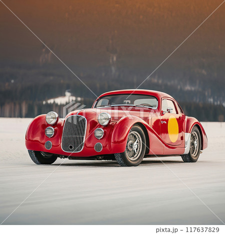 Red Vintage Racing Car on Snowy Terrain at Sunset 117637829