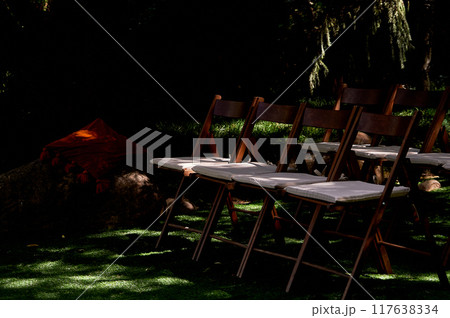 Open-air chairs for banquets, off-site registration. Rays of light on a green lawn 117638334