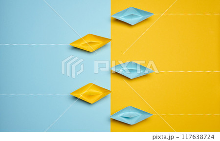 Paper boats on a yellow background, top view, representing the concept of unity and achieving common goals. Paper boats on a yellow background, top view, representing the concept of unity and achieving common goals. 117638724