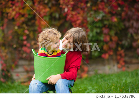 Child in fall park. Kid with autumn leaves. 117638790