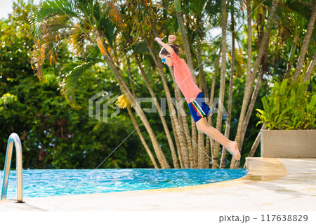 Kids jump into swimming pool. Summer water fun. Kids jump into swimming pool. Summer water fun. 117638829