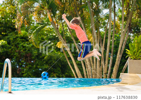 Kids jump into swimming pool. Summer water fun. Kids jump into swimming pool. Summer water fun. 117638830
