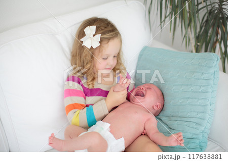 Siblings meet newborn baby Siblings meet newborn baby 117638881