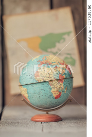 Vintage globe on stand with world map in the background 117639360