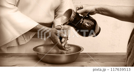 The servant pours water, and the master washes his hands 117639513