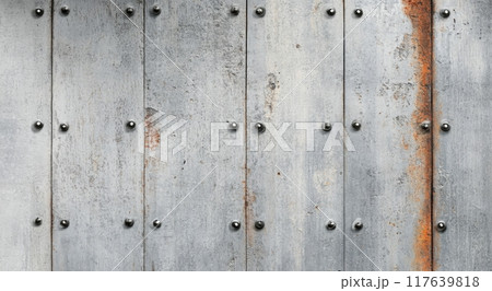 Weathered metal panels with rust and rivets on an industrial wall 117639818