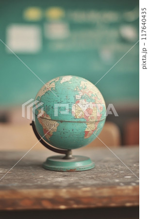 Vintage globe resting on a wooden table in a classroom setting 117640435