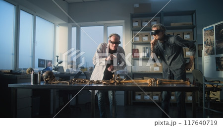 Two archaeologists study skeleton remains using virtual reality technology Two archaeologists study skeleton remains using virtual reality technology 117640719