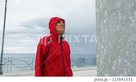 Man With Raincoat At The Seafront  117641531