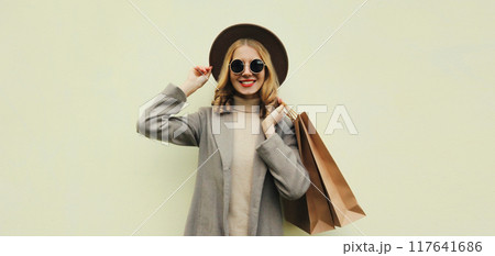 Autumn portrait of beautiful young woman with shopping bag, stylish girl in coat on brown background Autumn portrait of beautiful young woman with shopping bag, stylish girl in coat on brown background 117641686