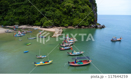 Aerial drone view of traditional colorful thai old wooden fishing boats on shore during low tide. Traditional Thai long-tailed fishing boats in tropical sea Aerial drone view of traditional colorful thai old wooden fishing boats on shore during low tide. Traditional Thai long-tailed fishing boats in tropical sea 117644259