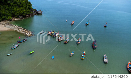 Aerial drone view of traditional colorful thai old wooden fishing boats on shore during low tide. Traditional Thai long-tailed fishing boats in tropical sea 117644260