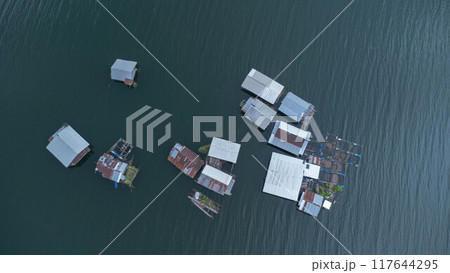 Aerial view of the River Kwai and floating houses in Kanchanaburi Province, Thailand. Beautiful view of floating cottages and Thai long-tail boats sailing on the River Kwai. 117644295