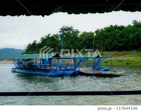 Local ferry transporting cars, motorcycles and people across a river in Kanchanaburi Province, Thailand. Local ferry transporting cars, motorcycles and people across a river in Kanchanaburi Province, Thailand. 117644336