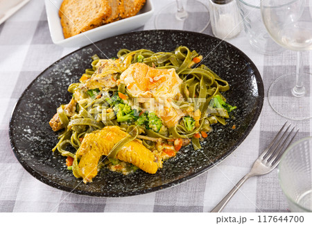Authentic Italian fettuccine pasta dish with chicken breast and broccoli on table 117644700