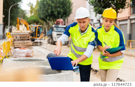 Two architects with laptop discussing construction plan 117644723