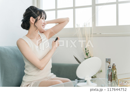 制汗剤スプレーを使う女性（脇・デオドラント） 117644752