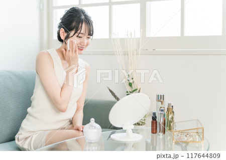 コットンで化粧水を肌につけるアジア人女性 117644809