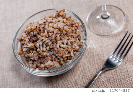 Plate of tasty buckwheat porridge on dining table 117644837