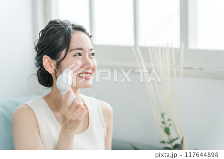 洗顔器・洗顔ブラシを使って洗顔する若いアジア人女性 洗顔器・洗顔ブラシを使って洗顔する若いアジア人女性 117644898