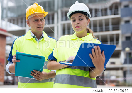 Two architects with laptop discussing construction plan 117645053