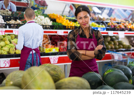 Woman presenting assortment in greengrocer 117645239