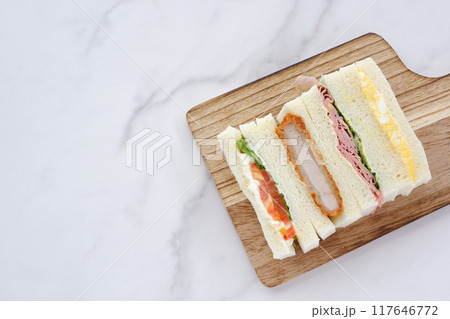 トンカツやタマゴ、ハム、生野菜のミックスサンドイッチでランチの時間 117646772