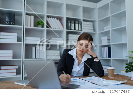 businesswoman plans a finance audit, reviewing documents while battling burnout syndrome. businesswoman plans a finance audit, reviewing documents while battling burnout syndrome. 117647487