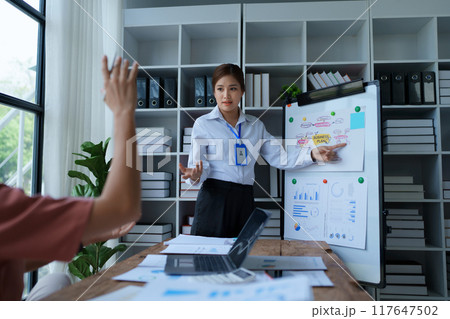 A businesswoman presents a marketing plan in the meeting room, strategically financial goals for successful execution A businesswoman presents a marketing plan in the meeting room, strategically financial goals for successful execution 117647502