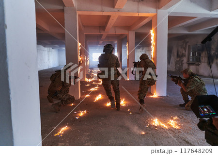 A professional cameraman captures the intense moments as a group of skilled soldiers embarks on a dangerous mission inside an abandoned building, their actions filled with suspense and bravery 117648209
