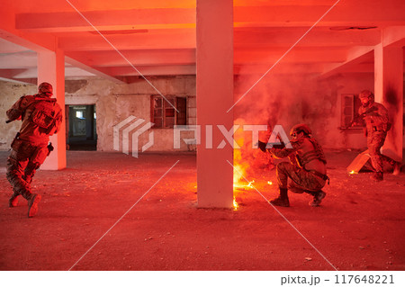 A group of professional soldiers bravely executes a dangerous rescue mission, surrounded by fire in a perilous building. A group of professional soldiers bravely executes a dangerous rescue mission, surrounded by fire in a perilous building. 117648221