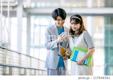 スマホを操作する男女 117648361