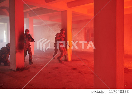A group of professional soldiers bravely executes a dangerous rescue mission, surrounded by fire in a perilous building. 117648388