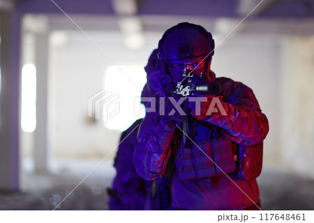 A group of professional soldiers bravely executes a dangerous rescue mission, surrounded by fire in a perilous building. 117648461