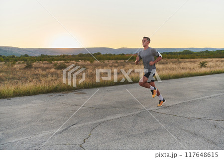 A young handsome man running in the early morning hours, driven by his commitment to health and fitness A young handsome man running in the early morning hours, driven by his commitment to health and fitness 117648615