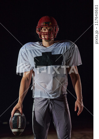 American Football Field: Lonely Athlete Warrior Standing on a Field Holds his Helmet and Ready to Play. Player Preparing to Run, Attack and Score Touchdown. 117648681