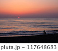 水平線に沈む夕日とビーチの二人 117648683