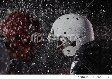 Two american football players face to face in silhouette shadow on white background Two american football players face to face in silhouette shadow on white background 117649085