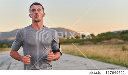 A young handsome man running in the early morning hours, driven by his commitment to health and fitness A young handsome man running in the early morning hours, driven by his commitment to health and fitness 117649222