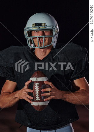 American Football Field: Lonely Athlete Warrior Standing on a Field Holds his Helmet and Ready to Play. Player Preparing to Run, Attack and Score Touchdown. 117649240