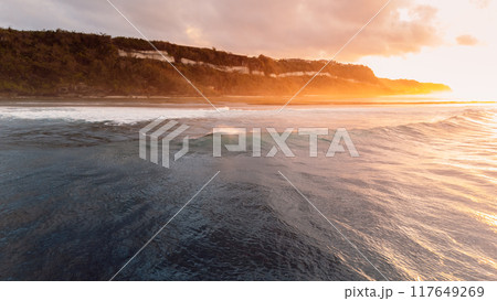 Bali coastline, ocean on low tide and waves with sunrise. Panoramic drone view 117649269