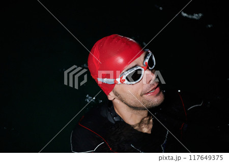 A triathlete finds serene rejuvenation in a lake, basking in the tranquility of the water after an intense training session A triathlete finds serene rejuvenation in a lake, basking in the tranquility of the water after an intense training session 117649375
