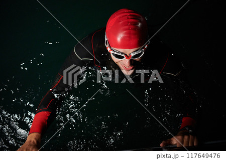 A triathlete finds serene rejuvenation in a lake, basking in the tranquility of the water after an intense training session A triathlete finds serene rejuvenation in a lake, basking in the tranquility of the water after an intense training session 117649476