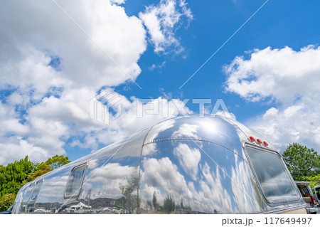 キャンピングトレーラーに写り込む青空　エアストリーム　アルミ流線形ボディー 117649497