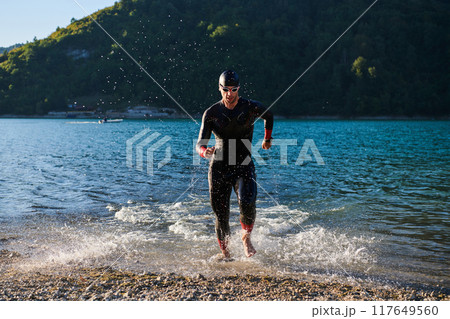 Triathlon athlete starting swimming training on lake 117649560