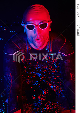 authentic triathlete swimmer having a break during hard training on night neon gel light 117649563