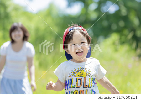 新緑の公園で走る男の子と見守る母親 117650211