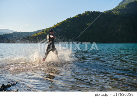 Triathlon athlete starting swimming training on lake 117650359