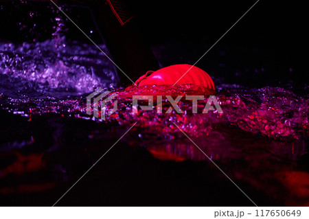 Authentic triathlete swimmer having a break during hard training on night neon gel light Authentic triathlete swimmer having a break during hard training on night neon gel light 117650649